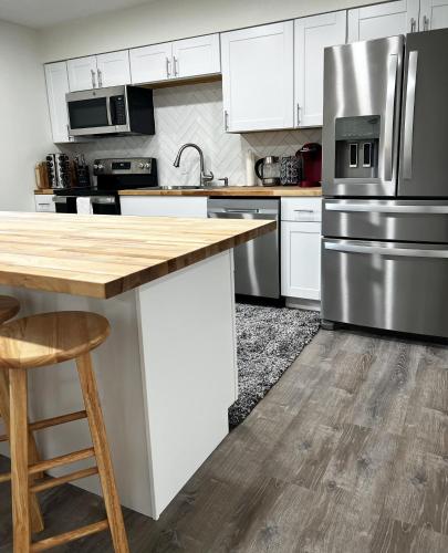 a kitchen with white cabinets and stainless steel appliances at Anchorage midtown apartment- Wyoming 1 in Anchorage