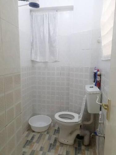 a white bathroom with a toilet and a window at Mombasa City Center Studio in Mombasa