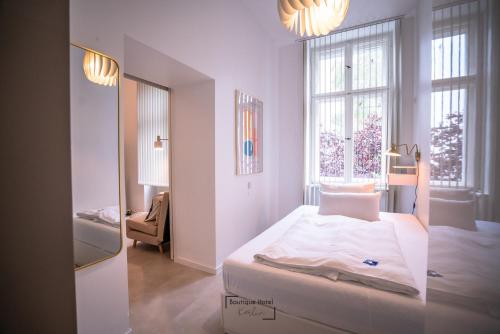 a white bedroom with a bed and a window at Boutique Hotel Kerlin in Berlin