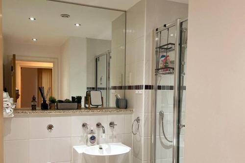 a white bathroom with a sink and a shower at Two-Bedroom Luxury Apartment with Workspace, Free Parking & coffee in Birmingham