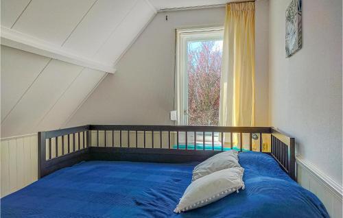 Schlafzimmer mit einem Bett mit blauer Bettwäsche und einem Fenster in der Unterkunft Gorgeous Home In Scharendijke With Kitchen in Scharendijke