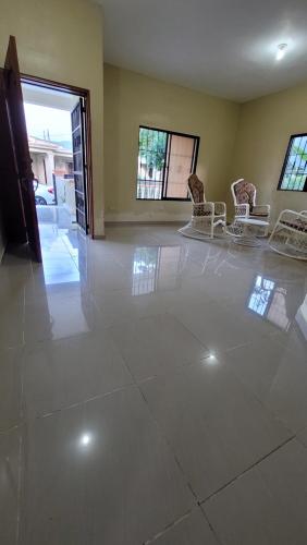 sala de estar con suelo de baldosa blanca y sillas en Jarabacoa Mountain Views, en Jarabacoa
