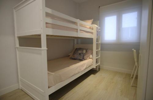 a white bunk bed in a room with a window at Apartamento nuevo, 3 dormitorios con terraza in Granada