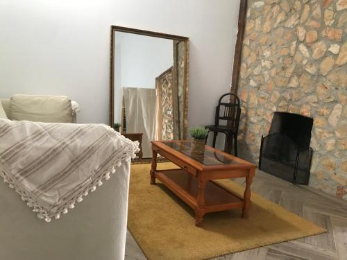 a living room with a table and a fireplace at Casa das Flores - no Parque Natural Guadiana in Mértola