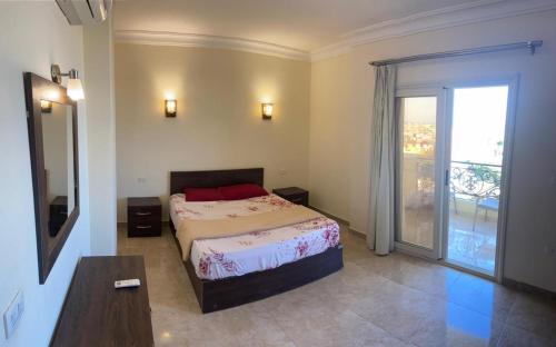 um quarto com uma cama e uma porta de vidro deslizante em Bahga Palace 5 Residential Apartments em Hurghada
