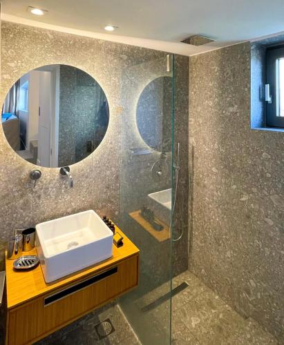 a bathroom with a sink and a mirror at Dimeli - Sea View Villas in Foinikounta in Finikounta