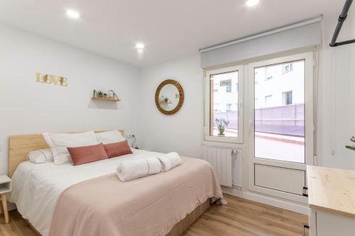 a white bedroom with a bed and a window at Apt in the Old Town with cool Terrace!! Private Parking in Bilbao
