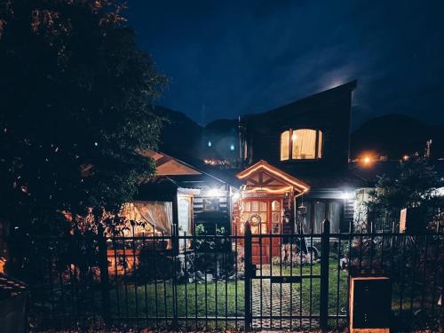 ein Haus mit einem Zaun davor in der Nacht in der Unterkunft Ulen in Ushuaia
