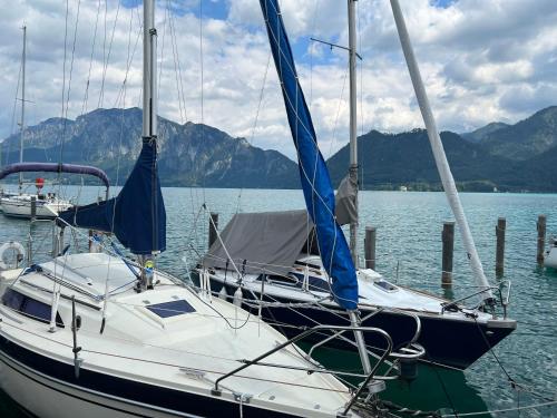 a sail boat docked at a dock in the water at Die Landhausvilla in Unterach am Attersee in Unterach am Attersee