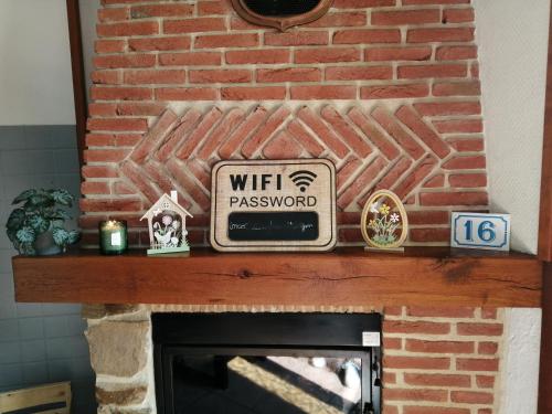 a brick fireplace with a sign on top of it at Escapade Normande SPA in Yerville