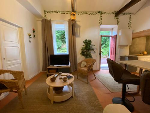 a living room with a table and a tv at Ribeira do Guilherme - Watermill house Botanic Garden in Nordeste