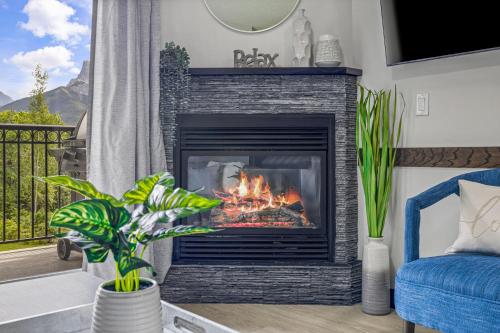 a fireplace in a living room with a blue couch at Outstanding Mountain Condo WATERSLIDE and HOT TUB managed by Little Sister Getaways in Canmore