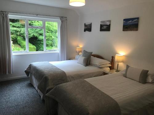 two beds in a room with a window at Snowdonia Mawddach escape in Dolgellau