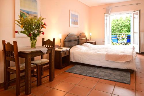 a bedroom with a bed and a table and a desk at Mira Mare Hotel, Galaxidi in Galaxidhion
