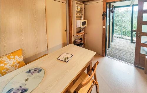 Cette chambre dispose d'une table, de deux chaises et d'un four micro-ondes. dans l'établissement Awesome Home In Ferrières-Poussarou, à Ferrières-Poussarou