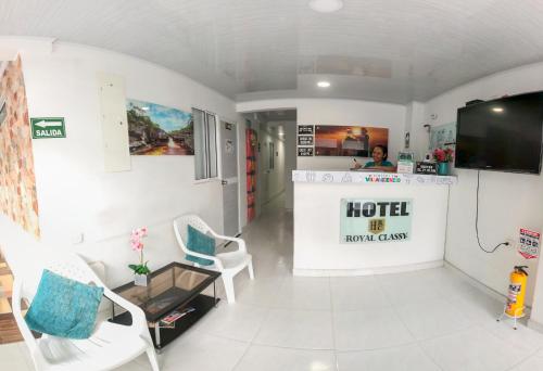 Cette chambre dispose d'un hall avec une télévision et des chaises. dans l'établissement Hotel Royal Classy, à Villavicencio