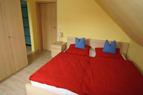 a bedroom with a red bed with blue pillows at Ferienhaus Halbritter Pouch in Pouch
