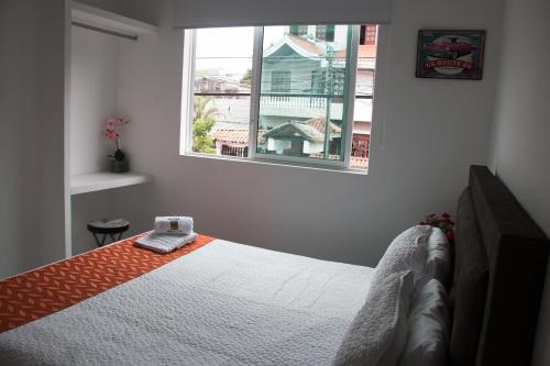 a bedroom with a bed and two windows at Hotel Royal Classy in Villavicencio