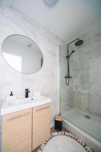 une salle de bain avec un lavabo, une baignoire et un miroir dans l'établissement F2 Cosy - Entrée du Havre - 4 personnes, au Havre