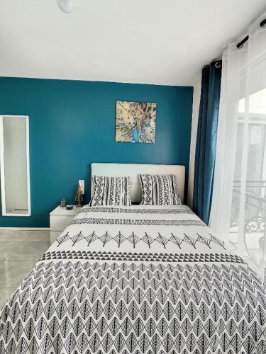 une chambre avec un grand lit avec un mur bleu dans l'établissement STUDIO COSY HYPER CENTRE GARE AMIENS WIFI NETFLIX 2 PERS, à Amiens