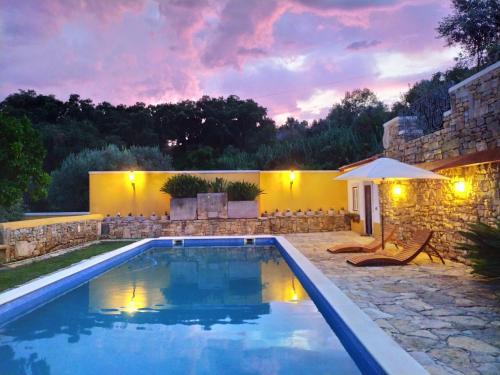 a pool in a backyard with a stone wall at Casarão do Largo da Eira in Tomar
