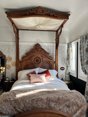 um quarto com uma cama grande e um dossel em madeira em Harbinson House em Sacramento