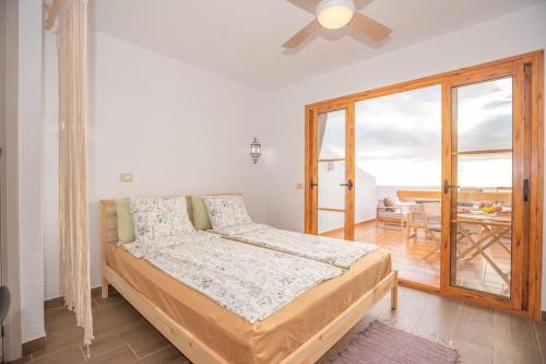 a bedroom with a bed and a sliding glass door at Port Royale Los Cristianos Arona in Los Cristianos