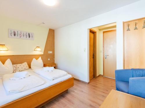 a bedroom with a bed and a blue chair at Chalet in Oberau near Ski Slopes in Oberau