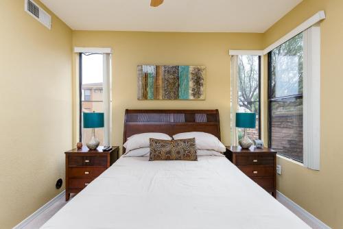 a bedroom with a large bed and two windows at Scottsdale Condo in Scottsdale