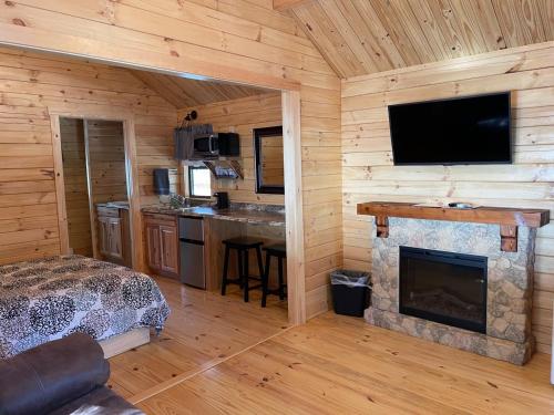 a bedroom with a fireplace in a log cabin at Lakewood Park Campground - Luxury Cabin in Barnesville