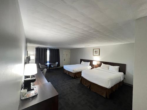 een hotelkamer met 2 bedden en een bureau bij Travelodge by Wyndham Cochrane in Cochrane