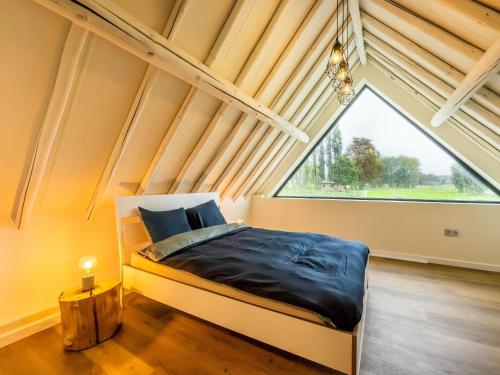 ein Schlafzimmer mit einem Bett und einem großen Fenster in der Unterkunft Lush holiday home in Vlaanderen with private pool 