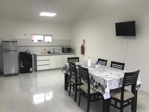 a dining room with a table with chairs and a kitchen at Berry Dpart in Ushuaia