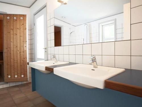 Baño con 2 lavabos y espejo en Holiday home Nexø XLII, en Neksø