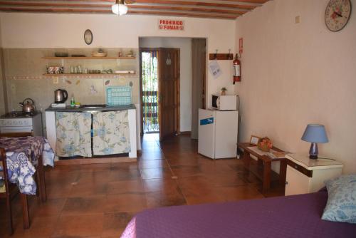 a room with a kitchen with a refrigerator and a table at Complejo Sol de Valizas in Barra de Valizas