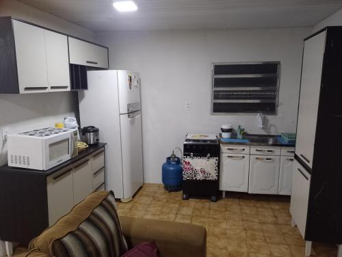 uma cozinha com um frigorífico branco e um micro-ondas em Real Hospedagem em Manaus