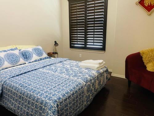 a bedroom with a blue and white bed with a window at Hidden Gem Cozy Home MiCasa TuCasa in El Paso