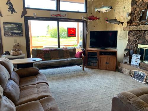 uma sala de estar com um sofá e uma televisão de ecrã plano em Clam Gulch Lodge em Clam Gulch