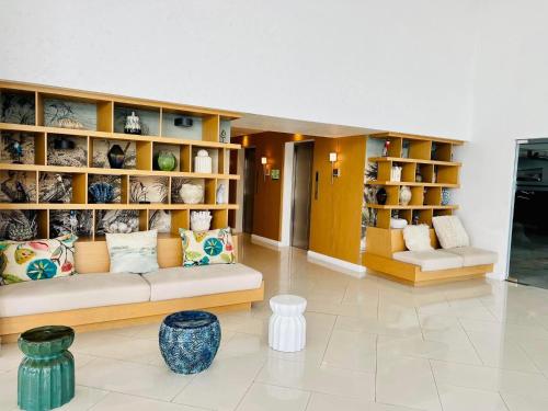 a living room with a couch and shelves of vases at 2305 Azure North Residence by Cozy Lodgings in San Fernando