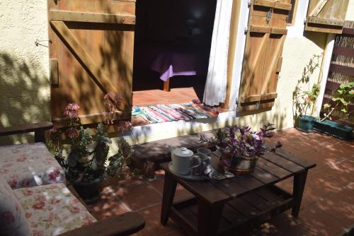 a patio with a table and a door with plants at Complejo Sol de Valizas in Barra de Valizas