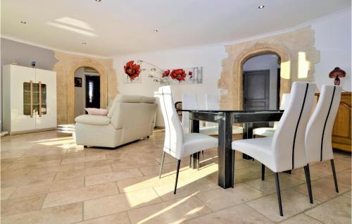 une salle à manger avec une table et des chaises blanches dans l'établissement Cozy Home In Jonquière Saint Vincen, à Jonquières-et-Saint-Vincent