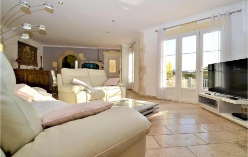 Il comprend un salon doté d'un mobilier blanc et d'une télévision. dans l'établissement Cozy Home In Jonquière Saint Vincen, à Jonquières-et-Saint-Vincent