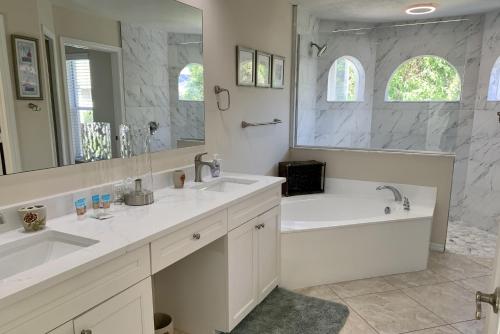 een badkamer met 2 wastafels en een grote spiegel bij Sunside House in Naples