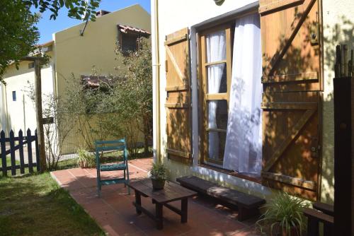 a patio with a table and a chair next to a house at Complejo Sol de Valizas in Barra de Valizas