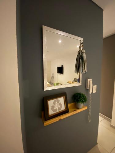 a bathroom with a mirror and a picture on a shelf at Departamento sobre el Rio. in Corrientes