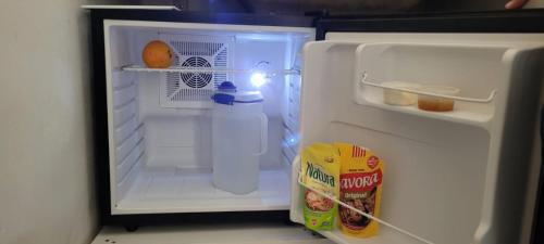 - un réfrigérateur ouvert avec une bouteille de lait et une boîte de nourriture dans l'établissement DEPARTAMENTO A&F II ALQUILER TEMPORARIO, à San Fernando del Valle de Catamarca