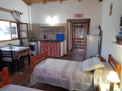 a kitchen with two beds and a table and a refrigerator at Complejo Sol de Valizas in Barra de Valizas