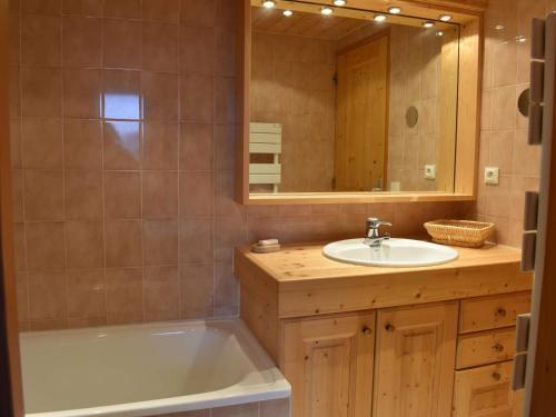 łazienka z wanną, umywalką i lustrem w obiekcie Duplex avec 4 chambres pour 10 à Méribel, proche pistes et commerces, parking inclus - FR-1-180-578 w mieście Les Allues