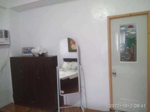 a room with a bedroom with a mirror and a dresser at Alona's Traditional Filipino Home near 100 Islands Wharf in Alaminos