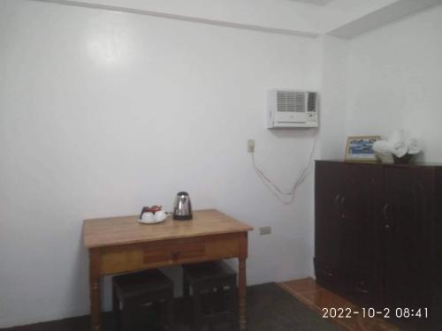 a room with a wooden table and a telephone on a wall at Alona's Traditional Filipino Home near 100 Islands Wharf in Alaminos